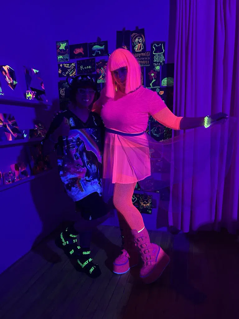 two people standing under black lights